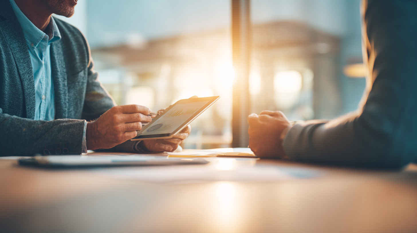 Reunión profesional entre dos personas con tablet, representando cómo elegir un proveedor de inteligencia artificial